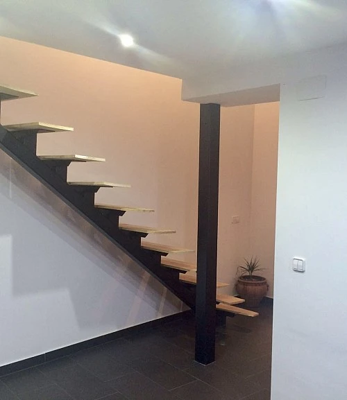 Escalera de zanca central, peldaños de madera y barandilla